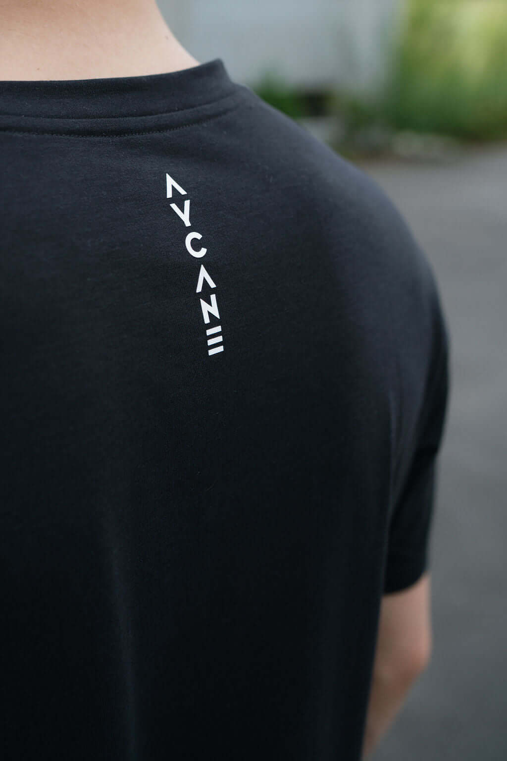 Back view of a black Route T-shirt featuring a stylish white graphic logo design.