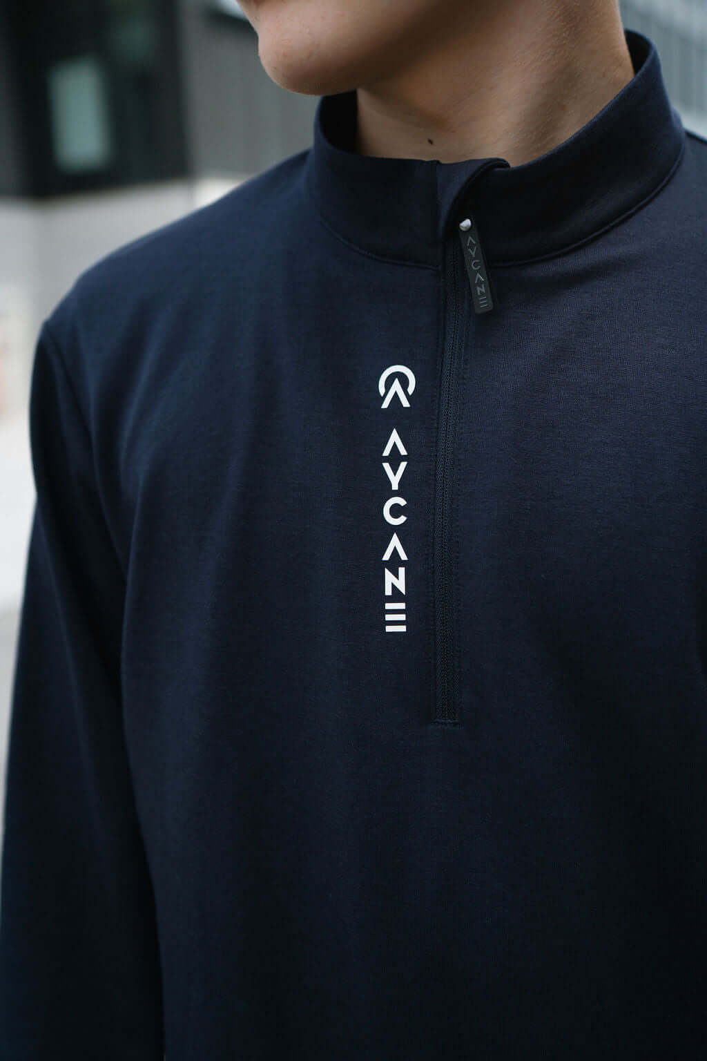 Model wearing a navy Maurize Halfzip midlayer with a half-zip collar and logo detail, perfect for warmth and comfort.