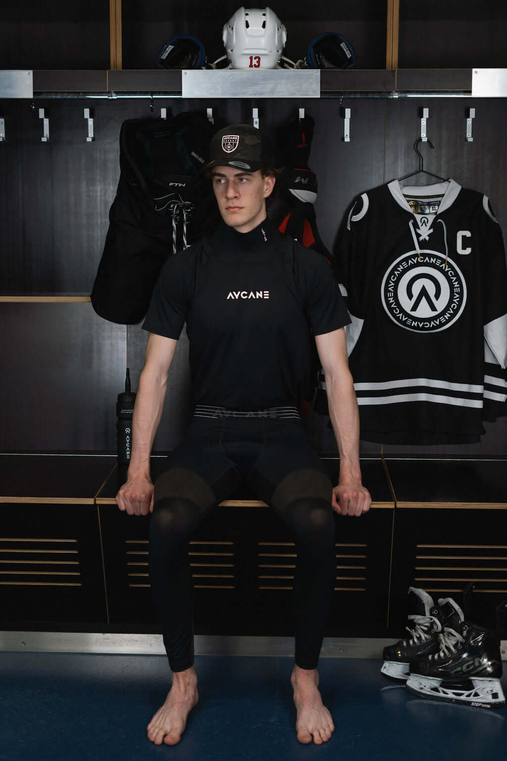 Male athlete wearing the Blade EVO 2 short sleeve base layer shirt in a locker room setting.