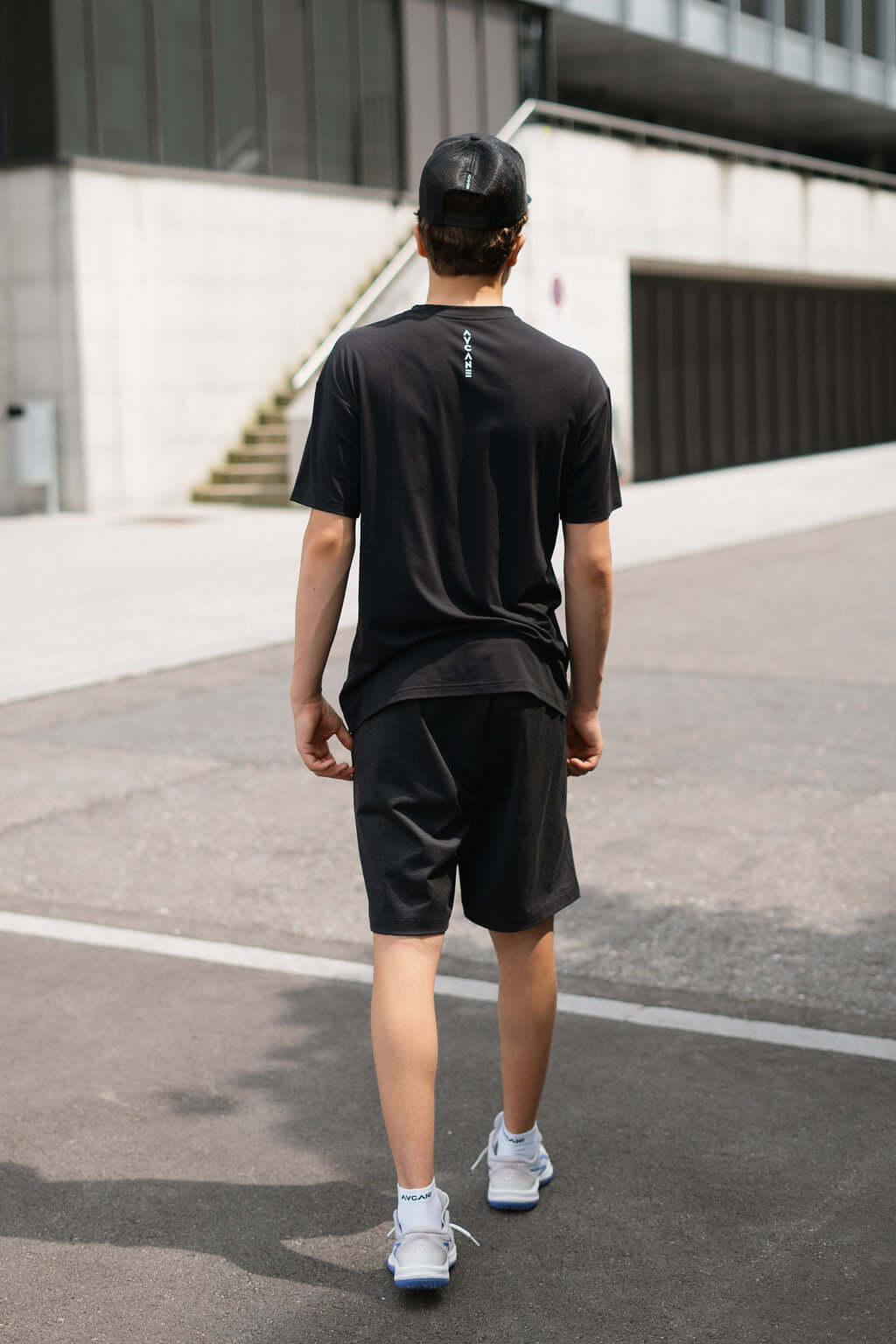 Man wearing Re.Force Shorts and black t-shirt outdoors, showcasing a sporty and casual look.