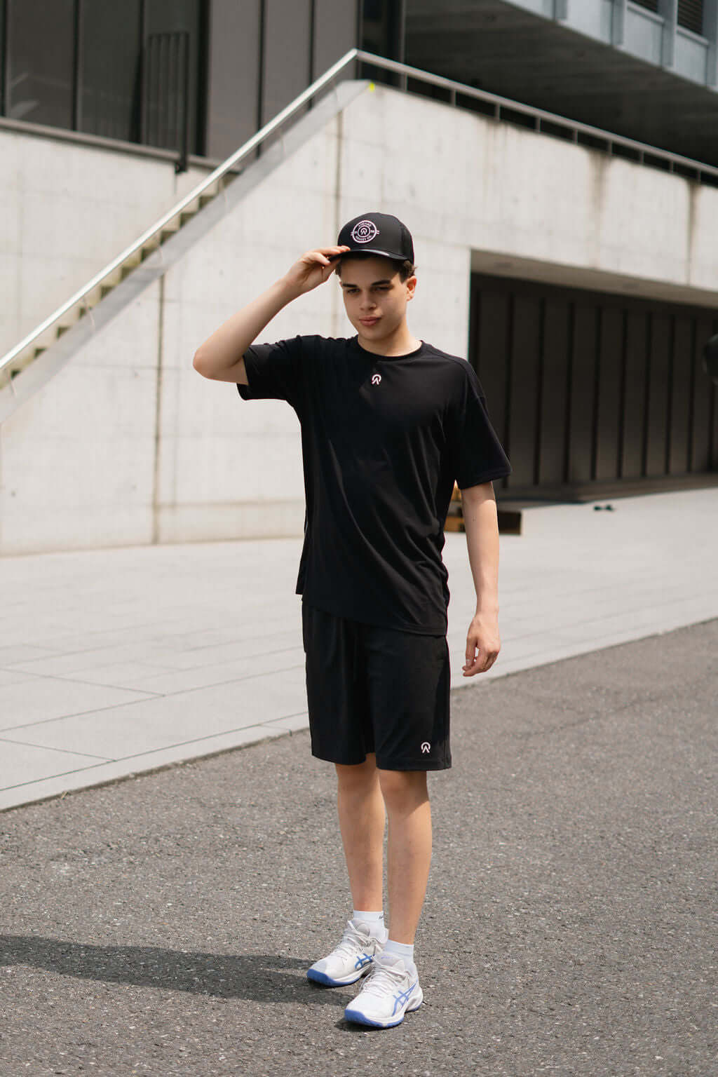 Model wearing a black Route Short Sleeve T-shirt and shorts, showcasing a sporty look outdoors.