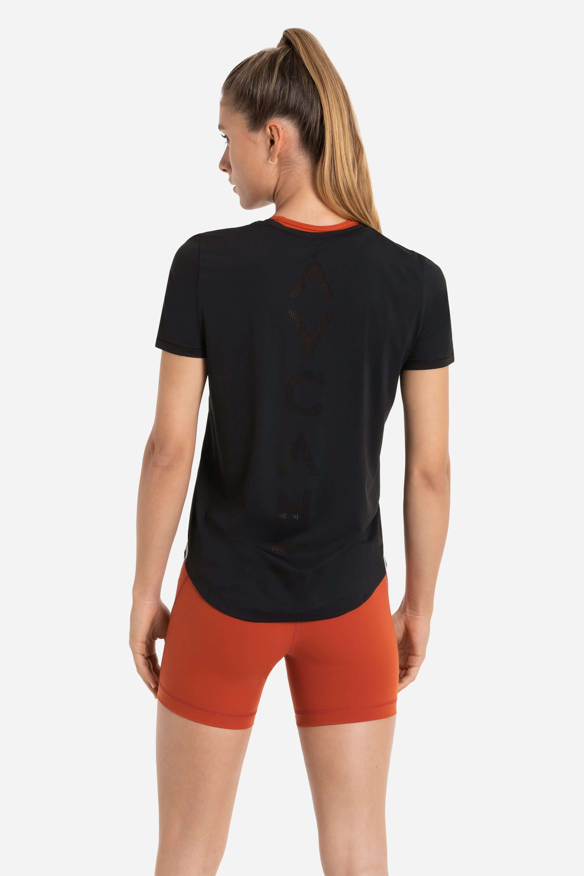 Women in a workout shirt short sleeve in black and short tights in red