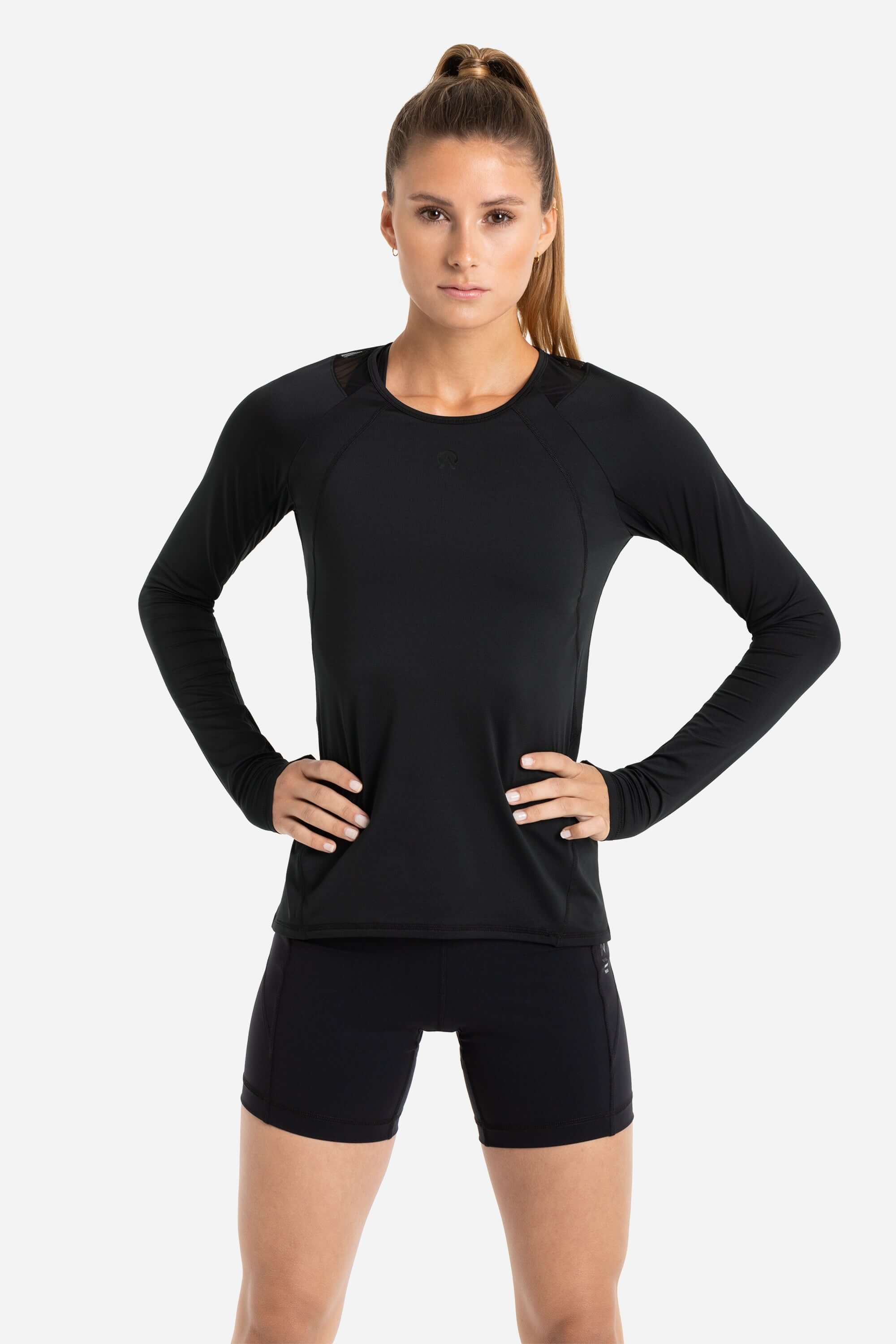 Women in a black long sleeve workout t-shirt with black short tights