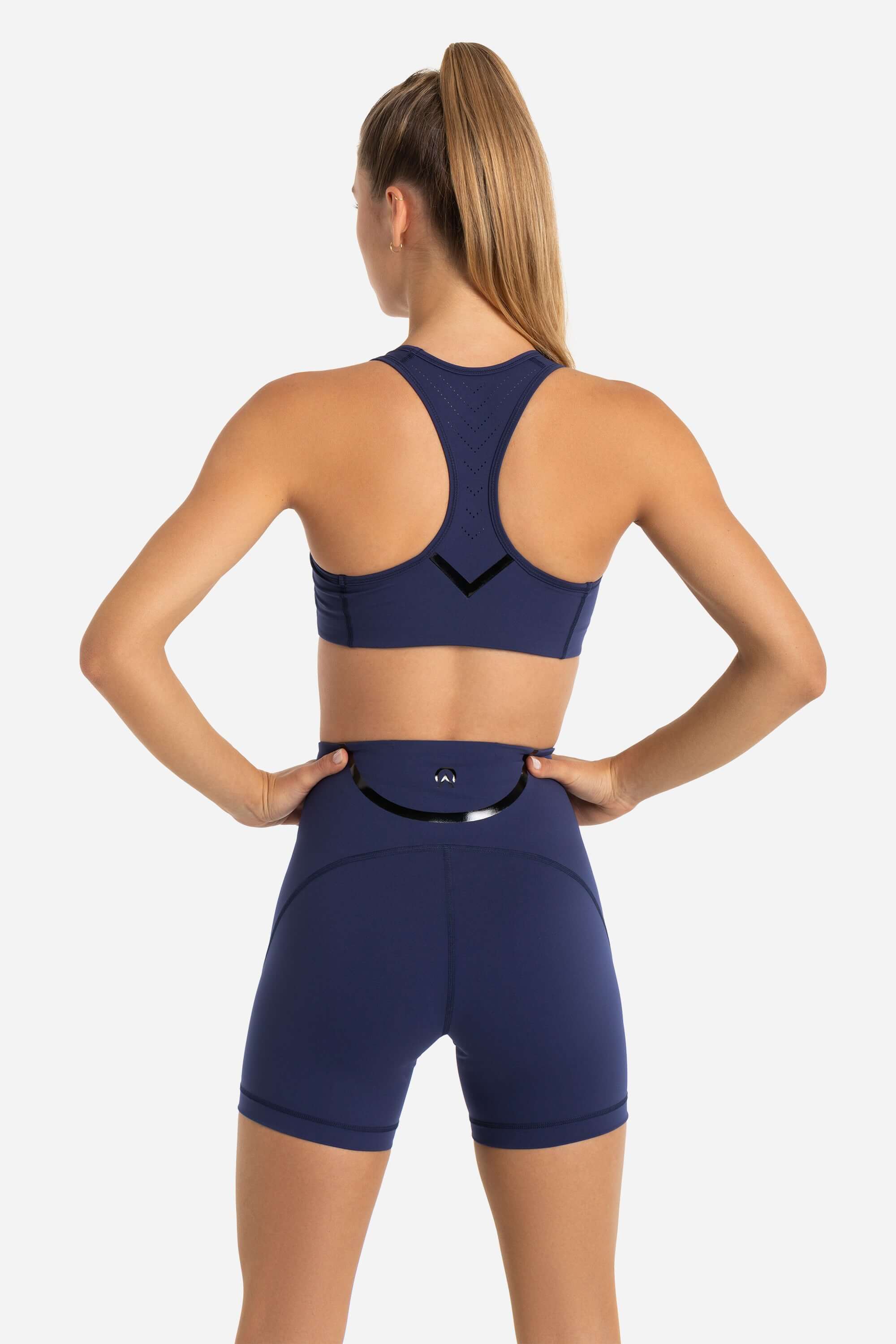 women in sports bra and short tights in blue