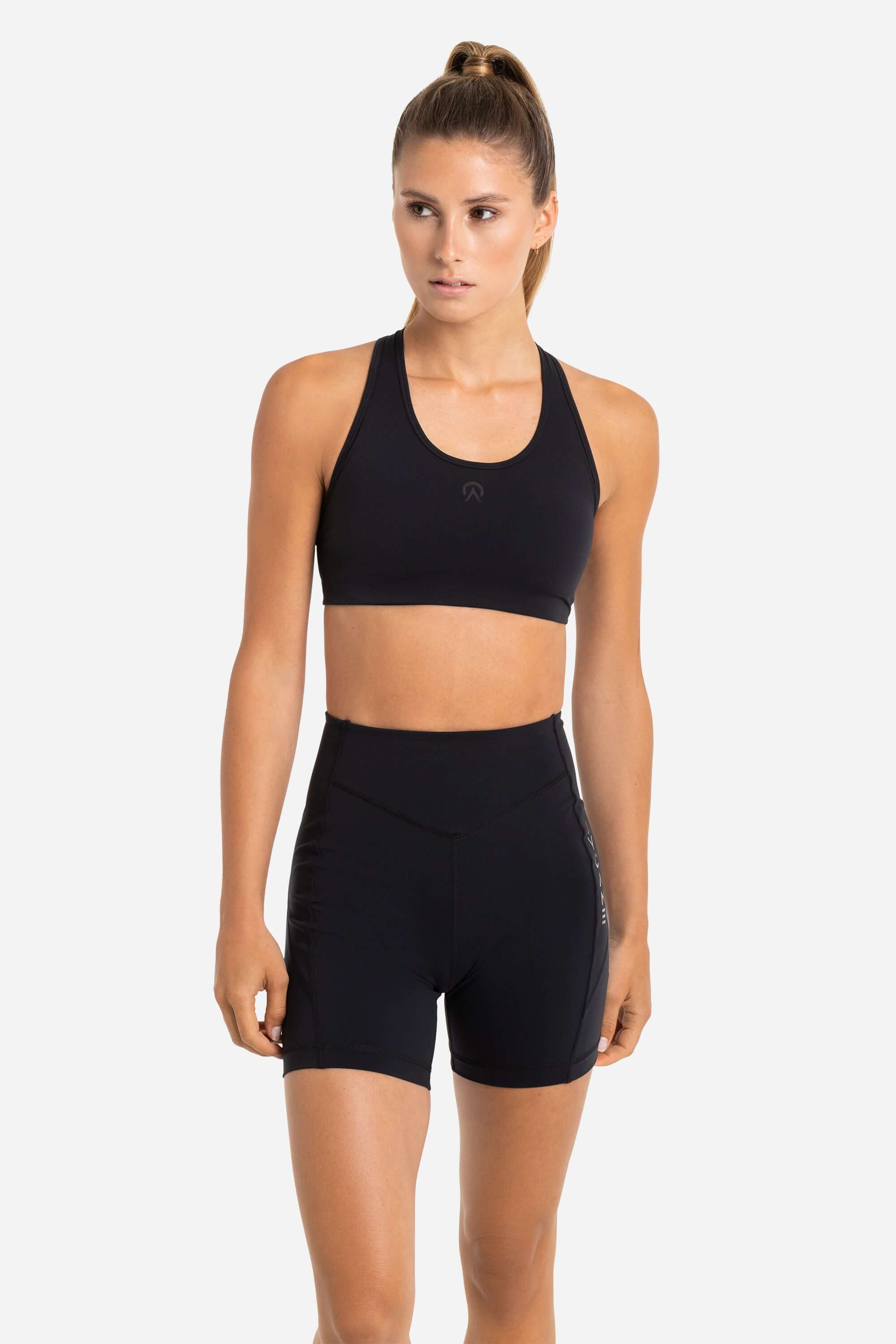 Women in a black sports bra and black short tights from AYCANE