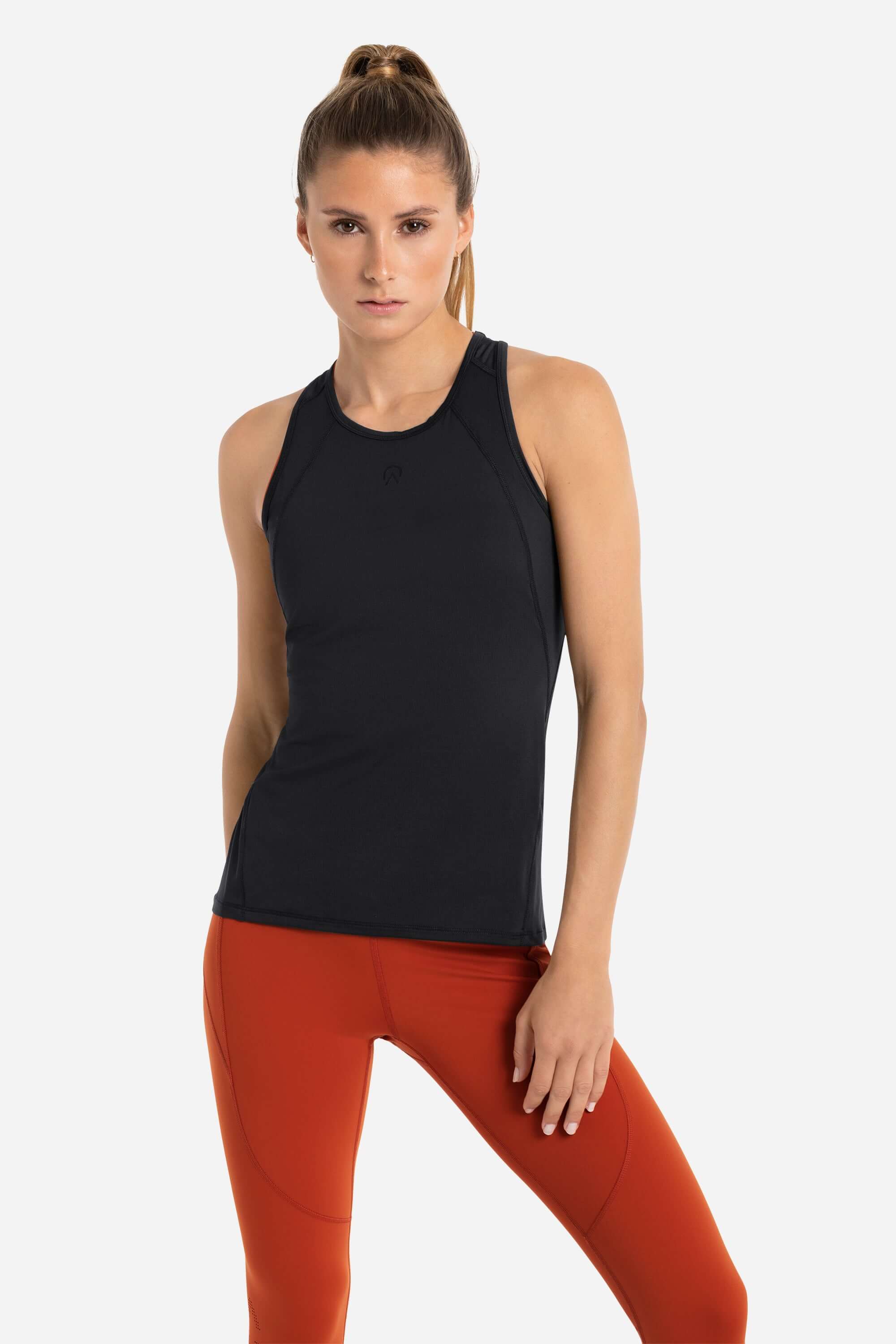 Women wearing a black workout tank top in black and red gym leggings from AYCANE