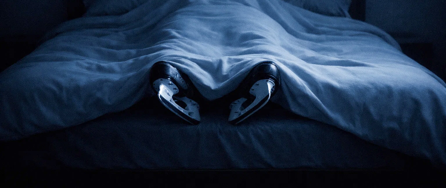 Youth and adult hockey players on an outdoor ice rink at dusk, looking toward the horizon, representing discipline, resilience, and life lessons from hockey.