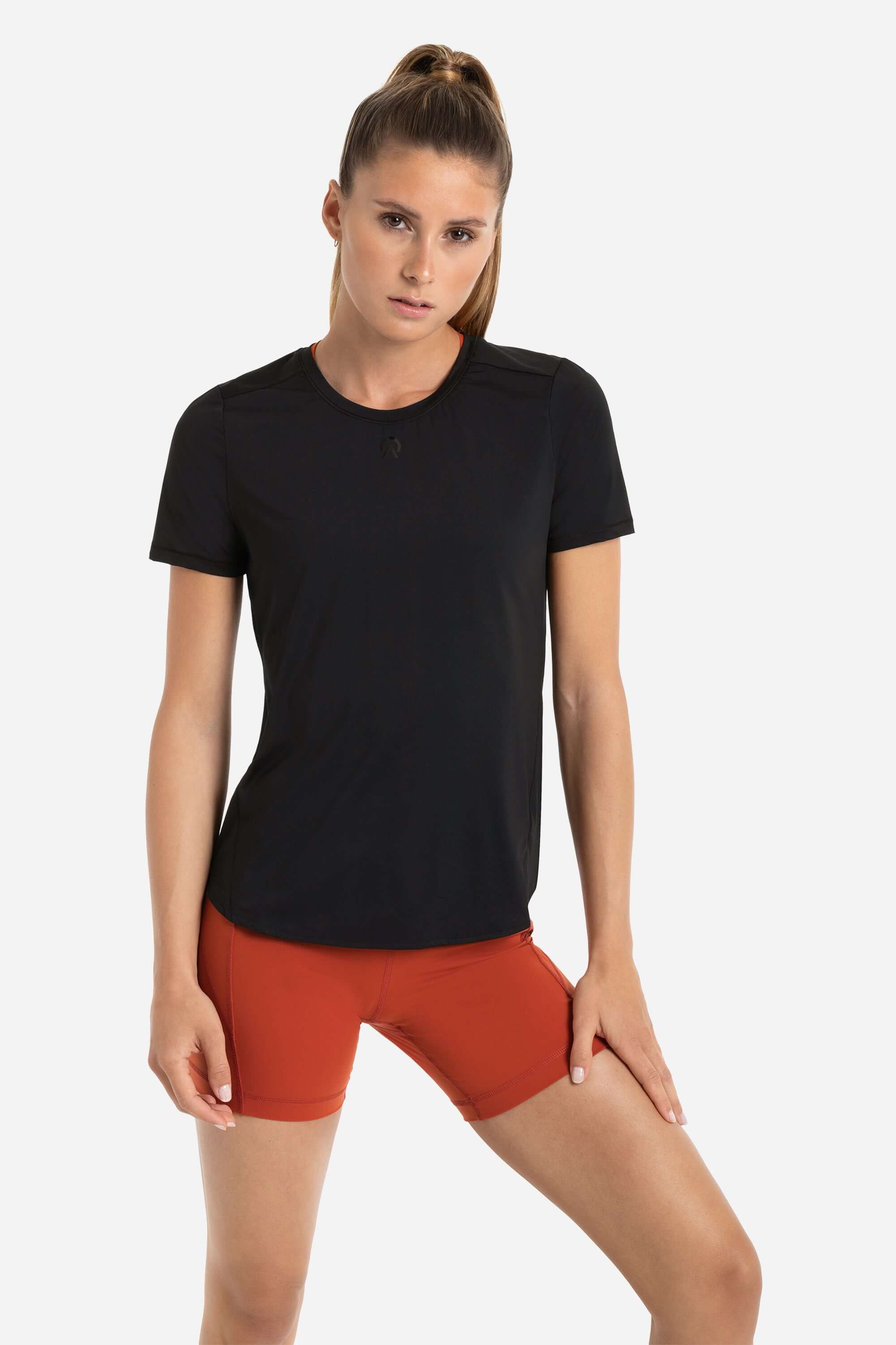 Women in a workout shirt short sleeve in black and short tights in red