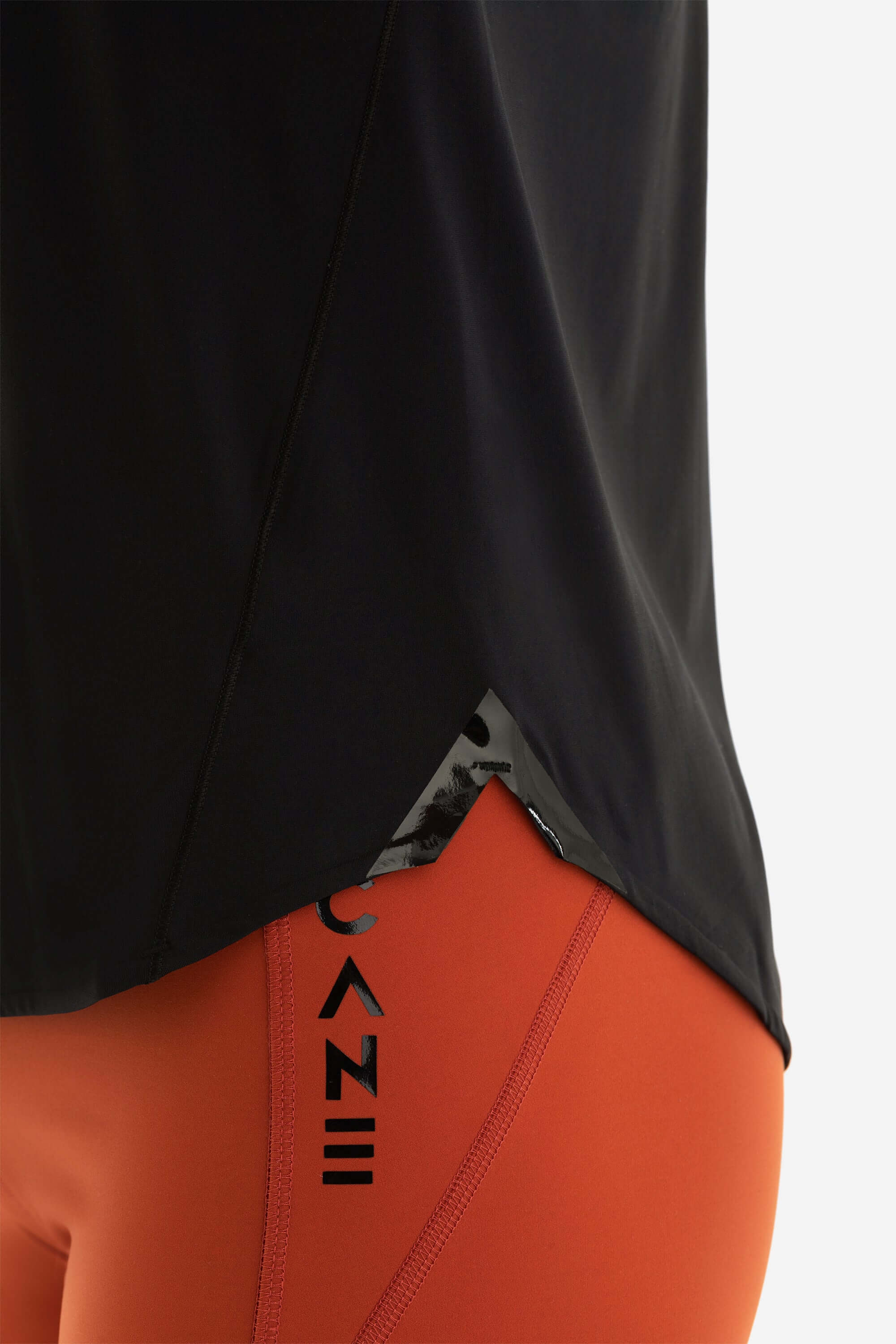 Close up of a women training shirt with design details shirt in black and shorts in red