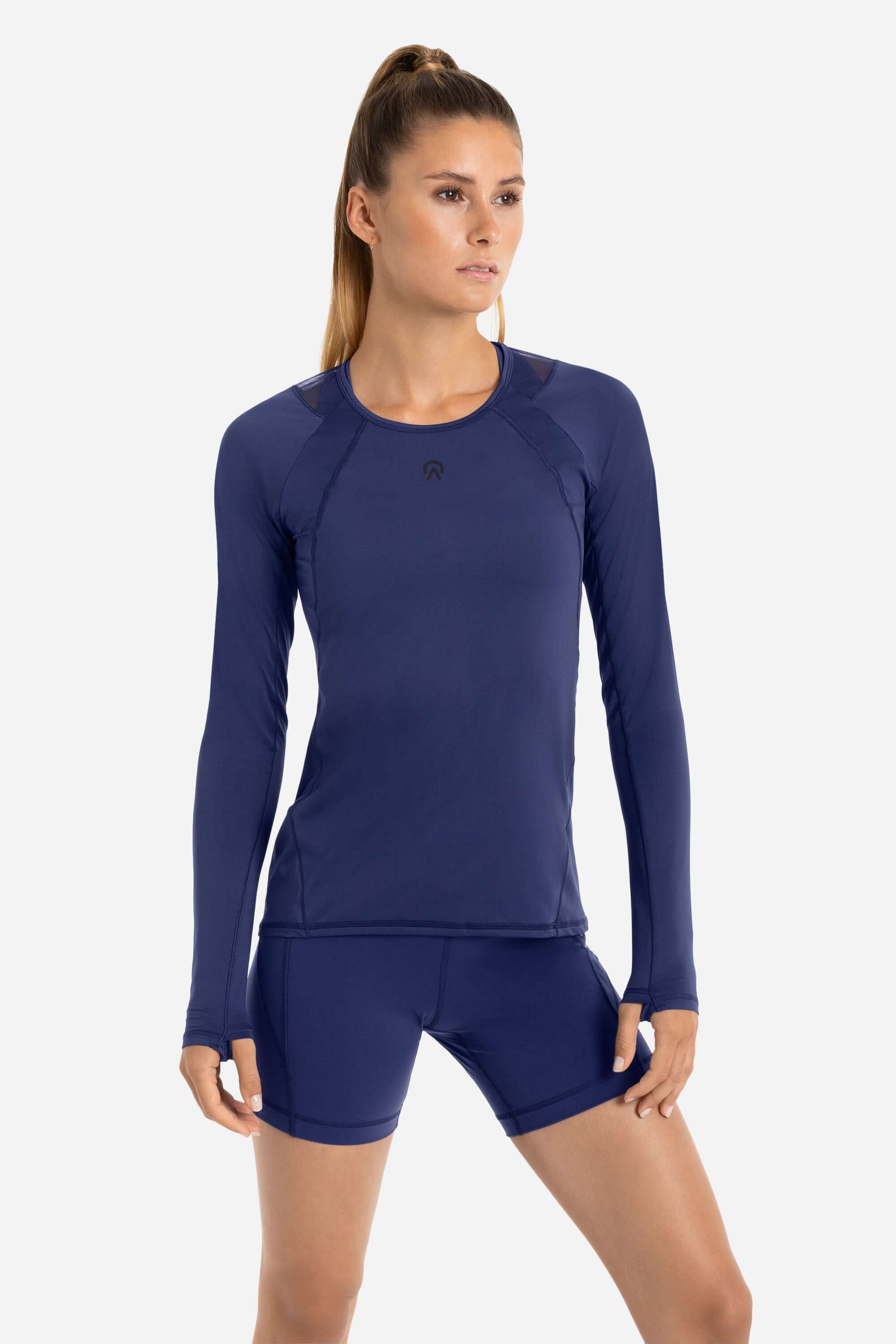 Women in a blue long sleeve workout t-shirt with blue short tights