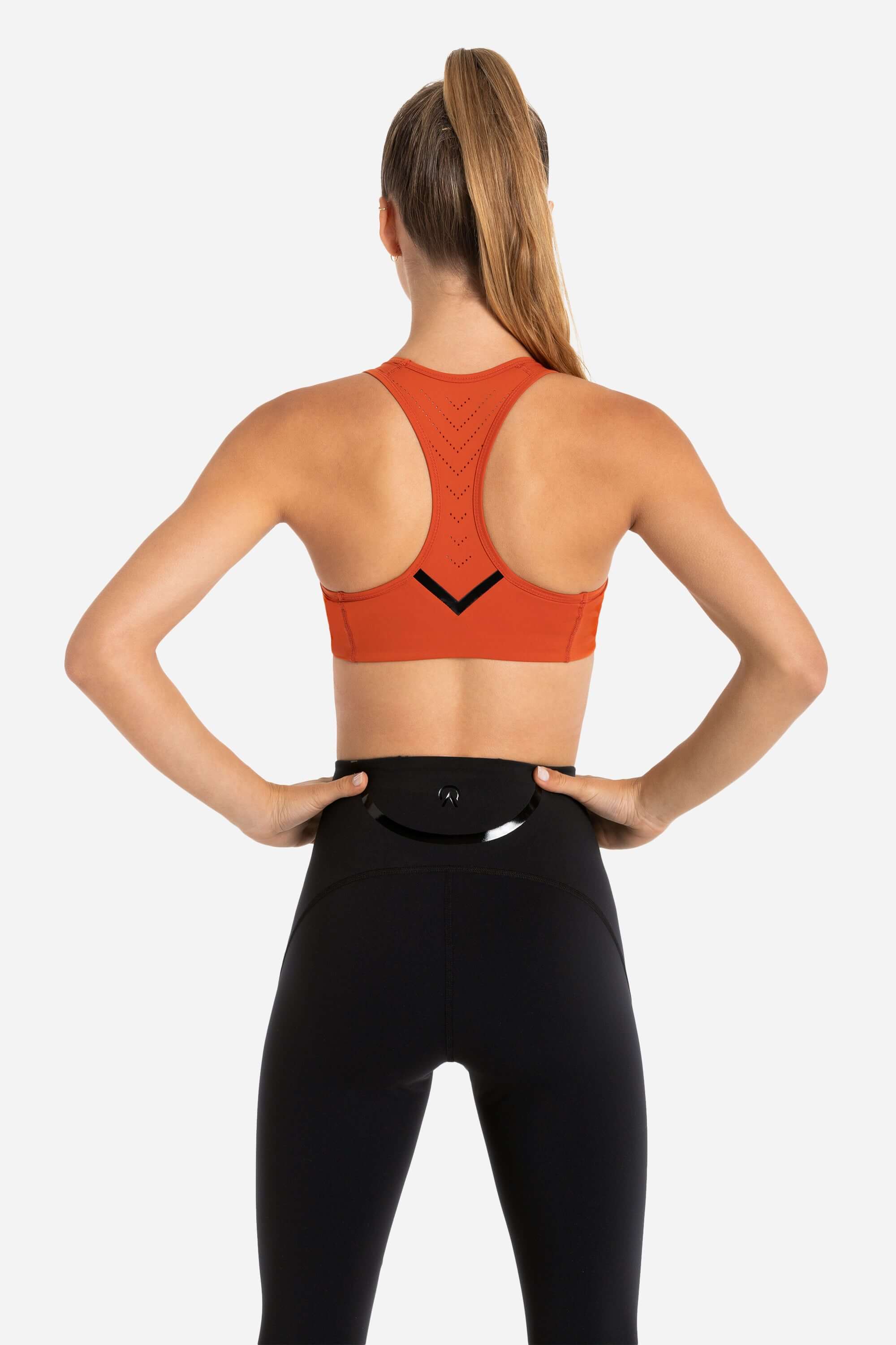 Women with hockey sports bra in red and black workout joggers