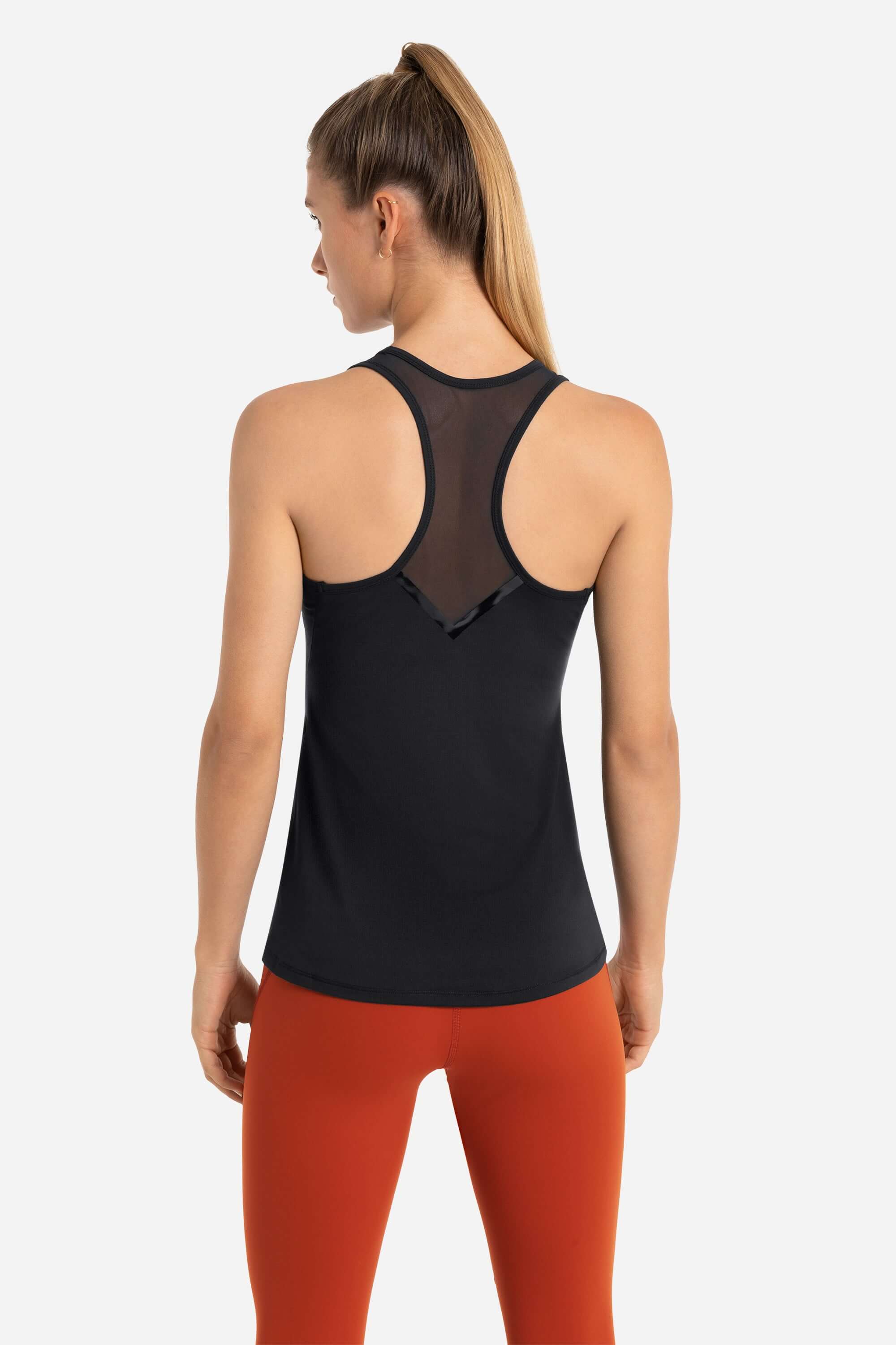 Women wearing a black workout tank top in black and red gym leggings from AYCANE